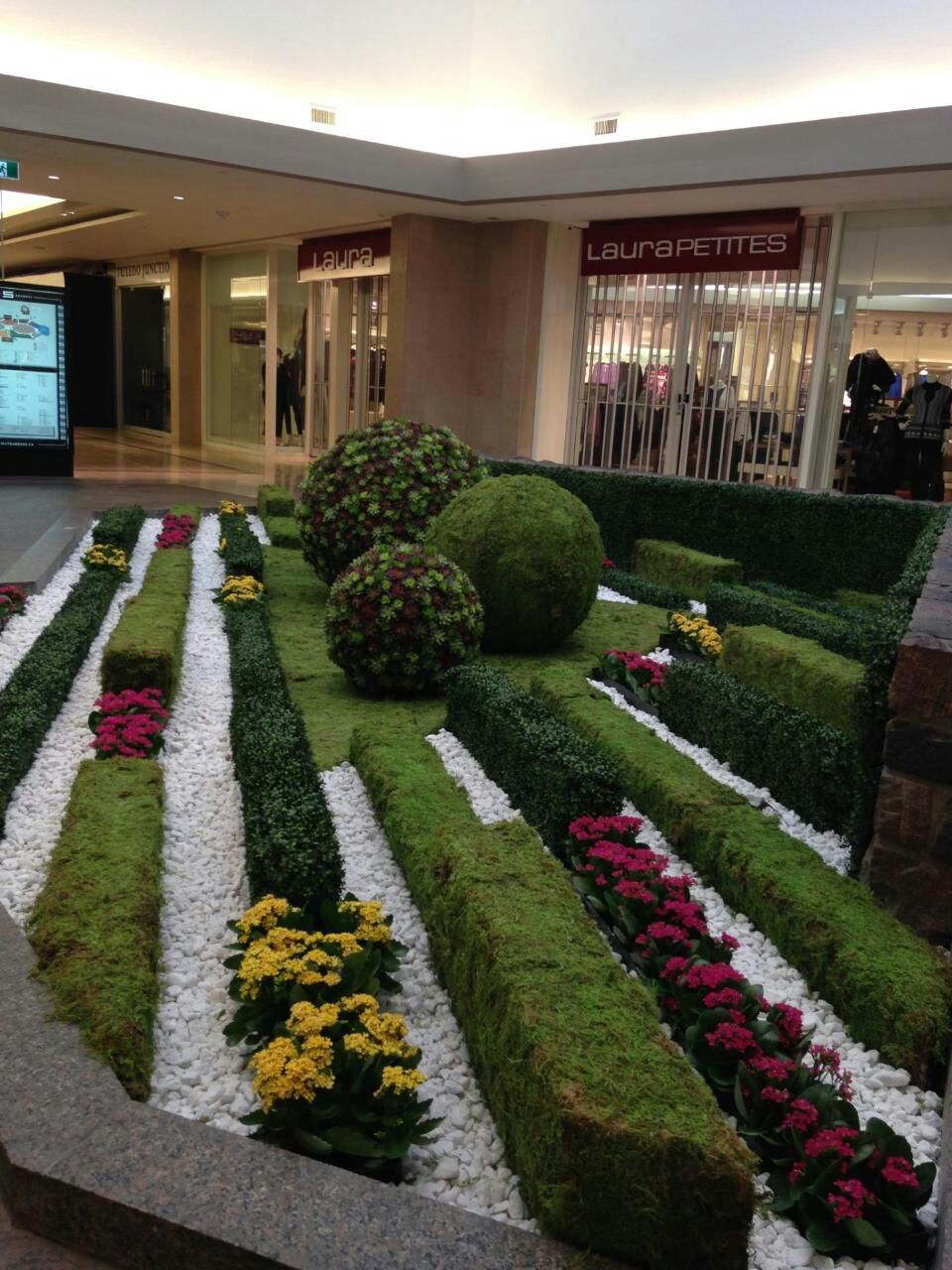 Shopping mall interior with elaborate topiary sculptures and seasonal floral display - commercial interior landscaping Southwest Florida