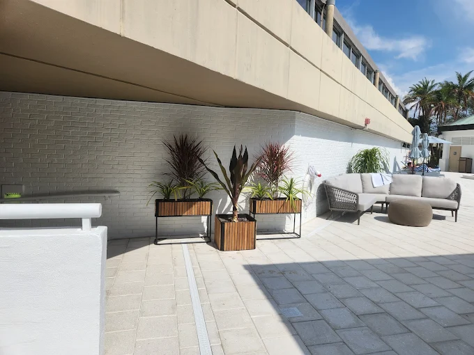 Outdoor terrace landscaping with custom wooden planters and tropical greenery for Sarasota commercial property